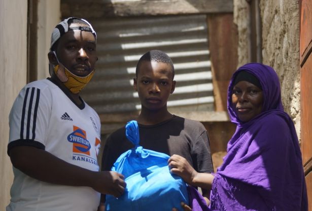 Hilfe, die ankommt: Shem Lumumba übergibt eines der Essenspakete. Es enthält 4 kg Maismehl, 4 kg Weizenmehl, 1 Liter Speiseöl und 1 kg Zucker. Je nach Größe der Familie reicht dieser Vorrat ca. 4-7 Tage.
